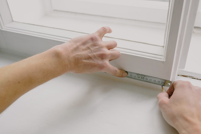 property maintenance worker measuring window